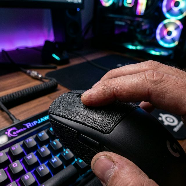 Dito che esegue un Drag Click su un mouse gaming con grip tape